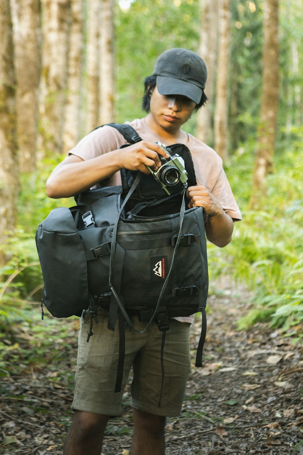 man in brown t-shirt and brown pants carrying black backpack