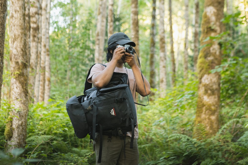 man in black t-shirt and brown cargo pants holding black dslr camera
