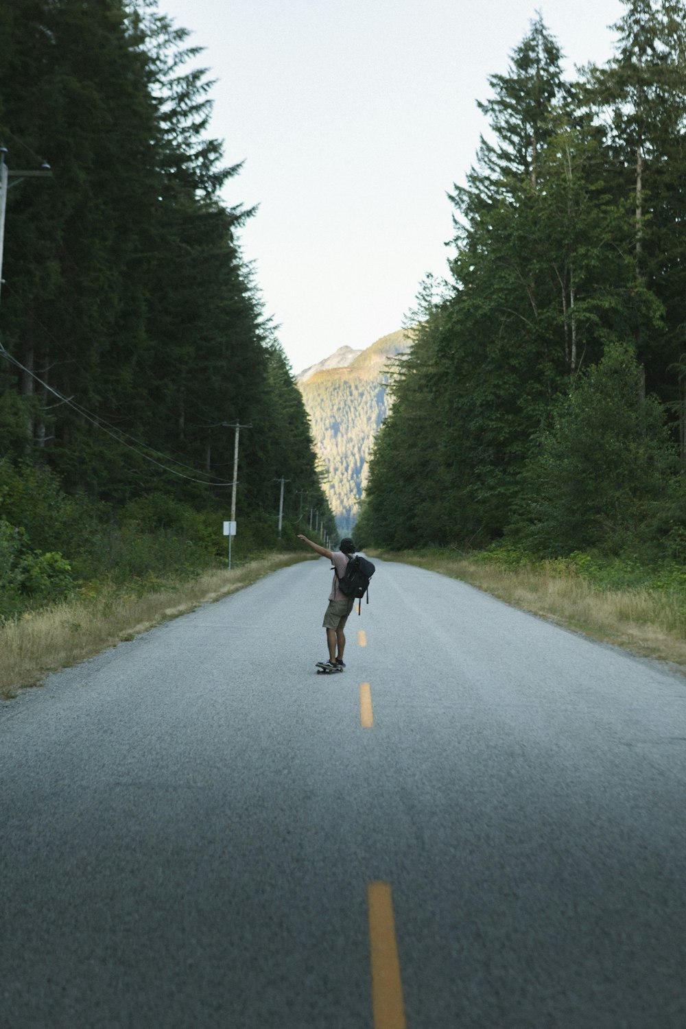 man in black shirt and black shorts running on road during daytime