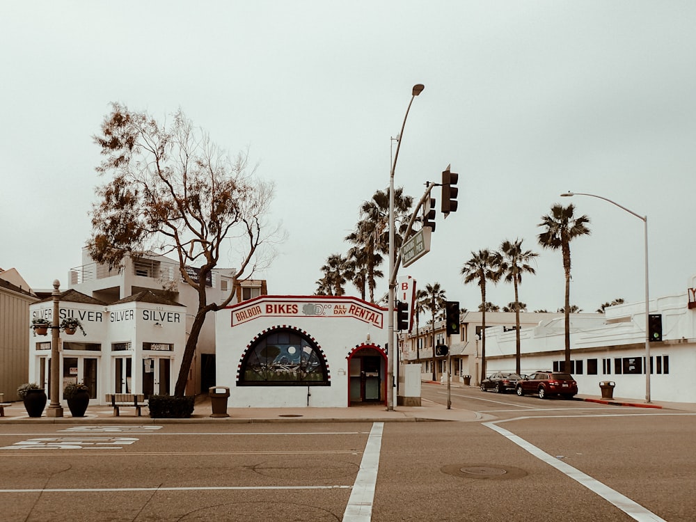 cars parked in front of white concrete building during daytime