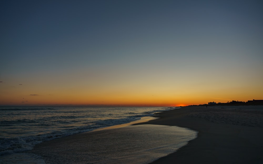 sea waves crashing on shore during sunset