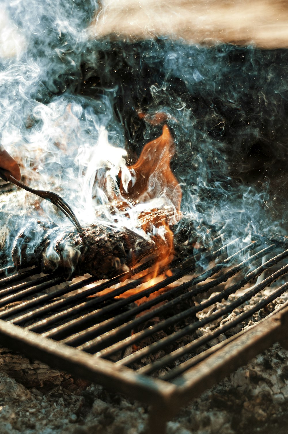 person cooking on grill with fire