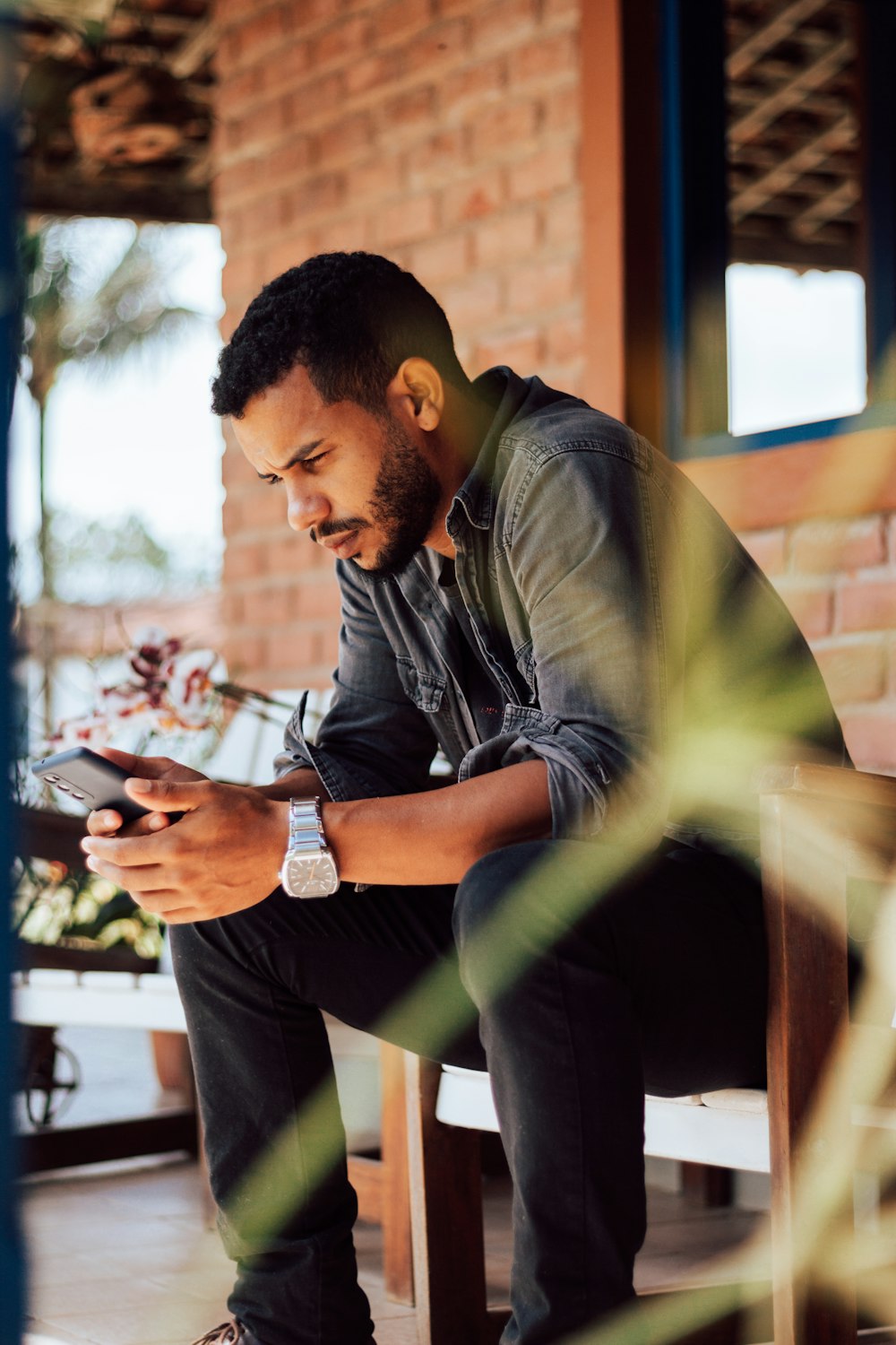 man in gray shirt using smartphone