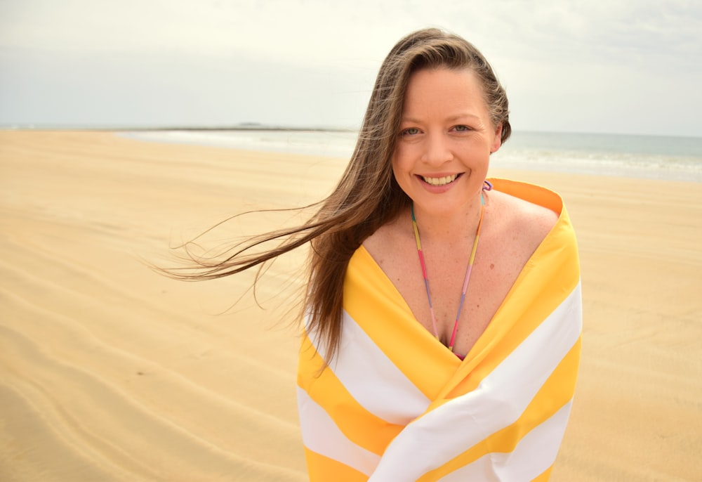 mulher no vestido listrado amarelo e branco na praia