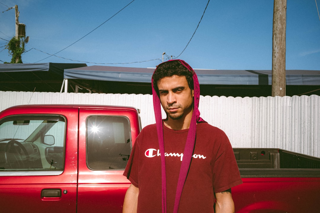 woman in red crew neck t-shirt standing beside red car