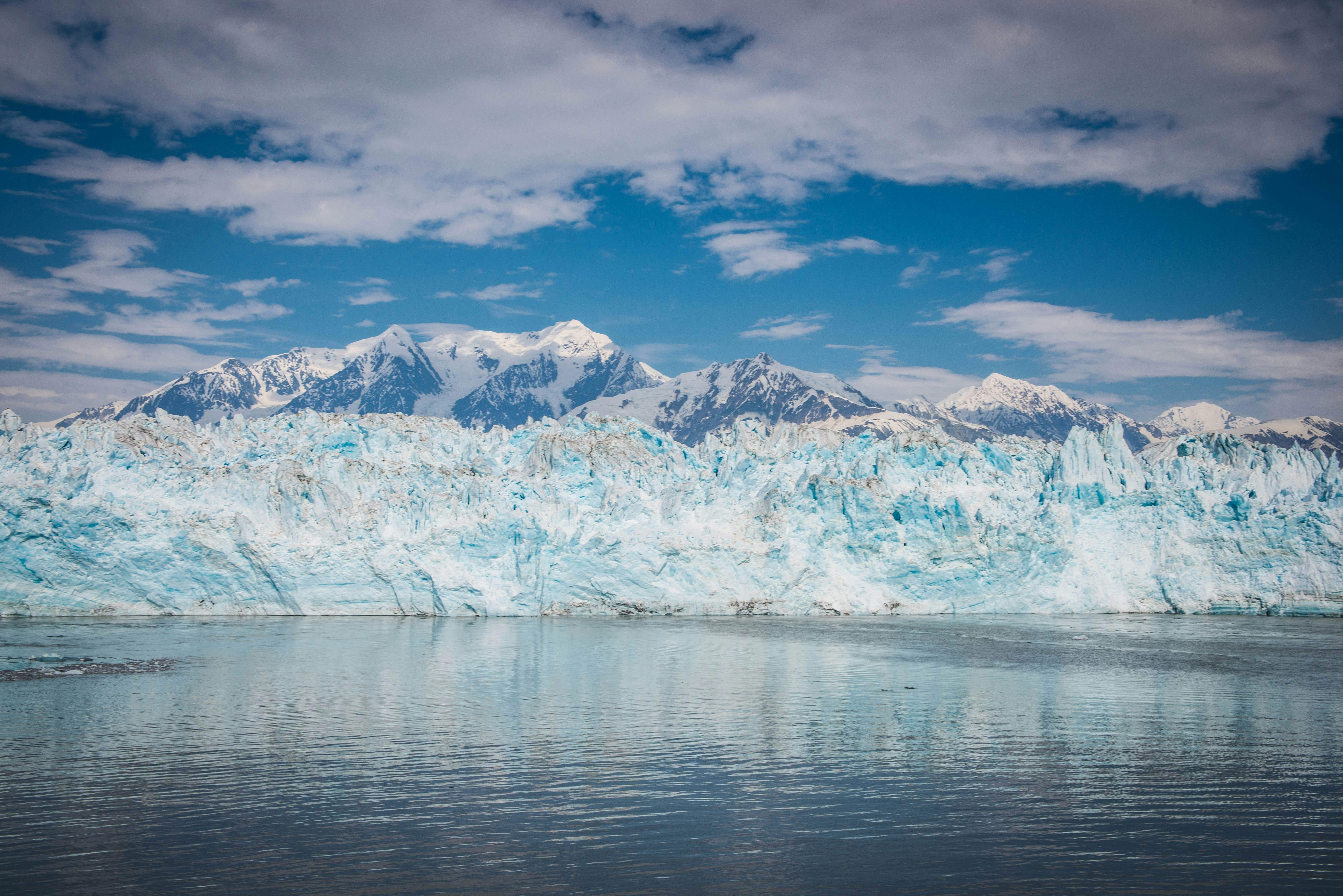 body of water near mountain under blue sky during daytime, 