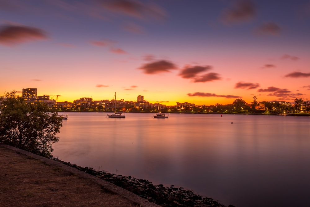 body of water near city during sunset