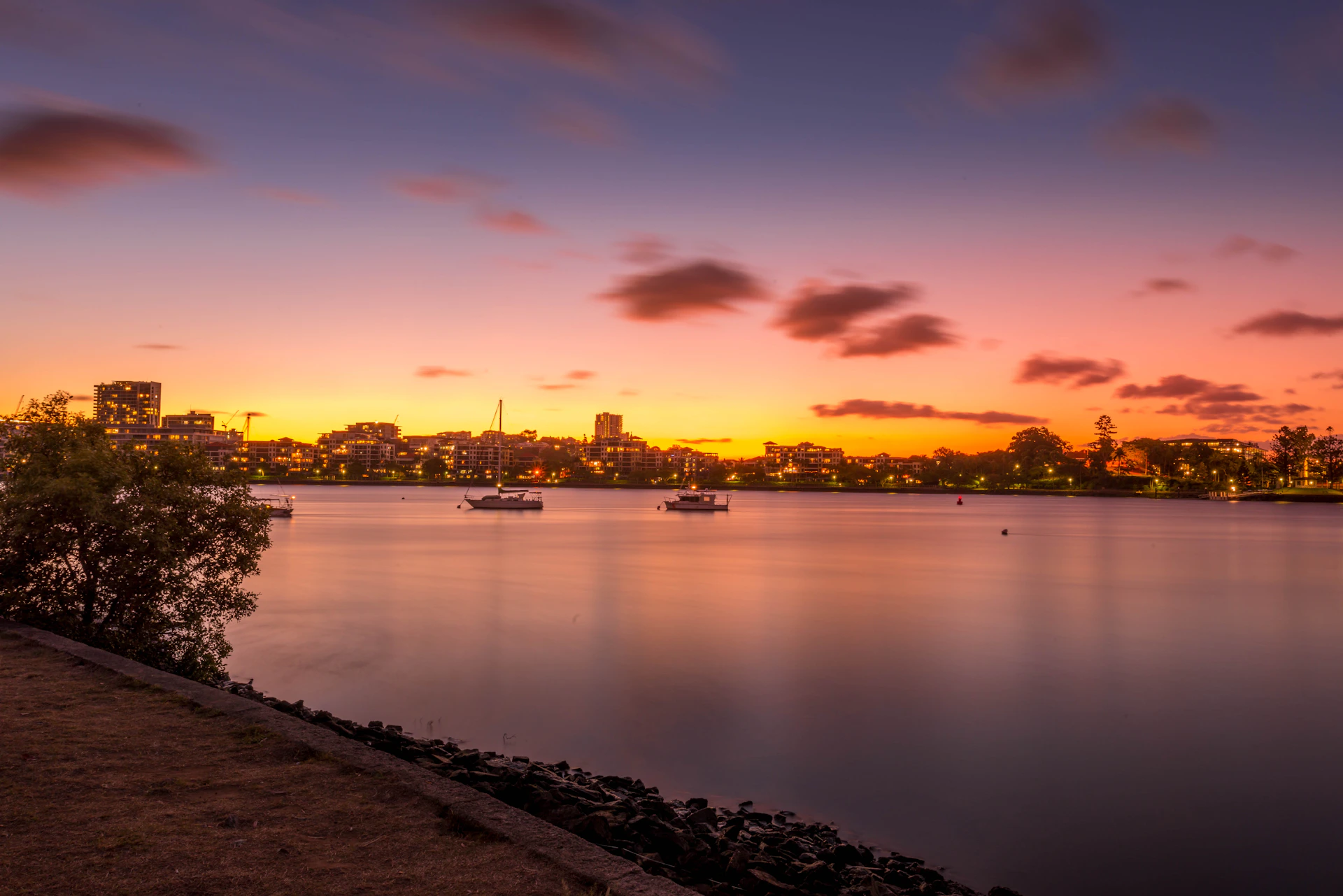 body of water near city during sunset