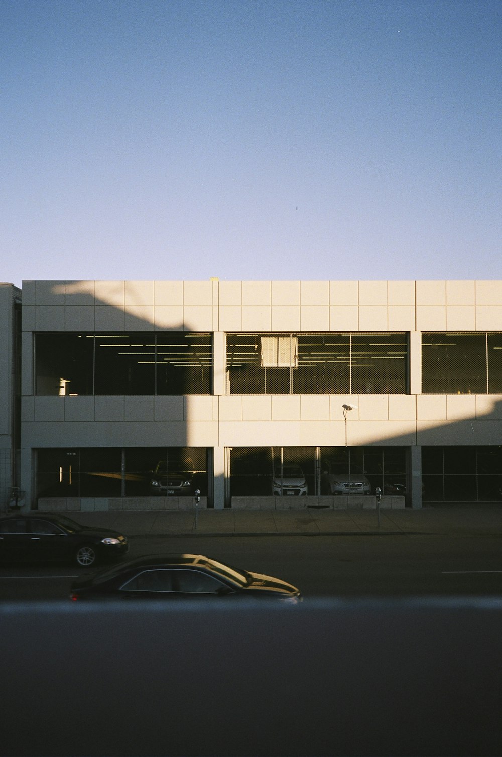 black sedan parked in front of white building