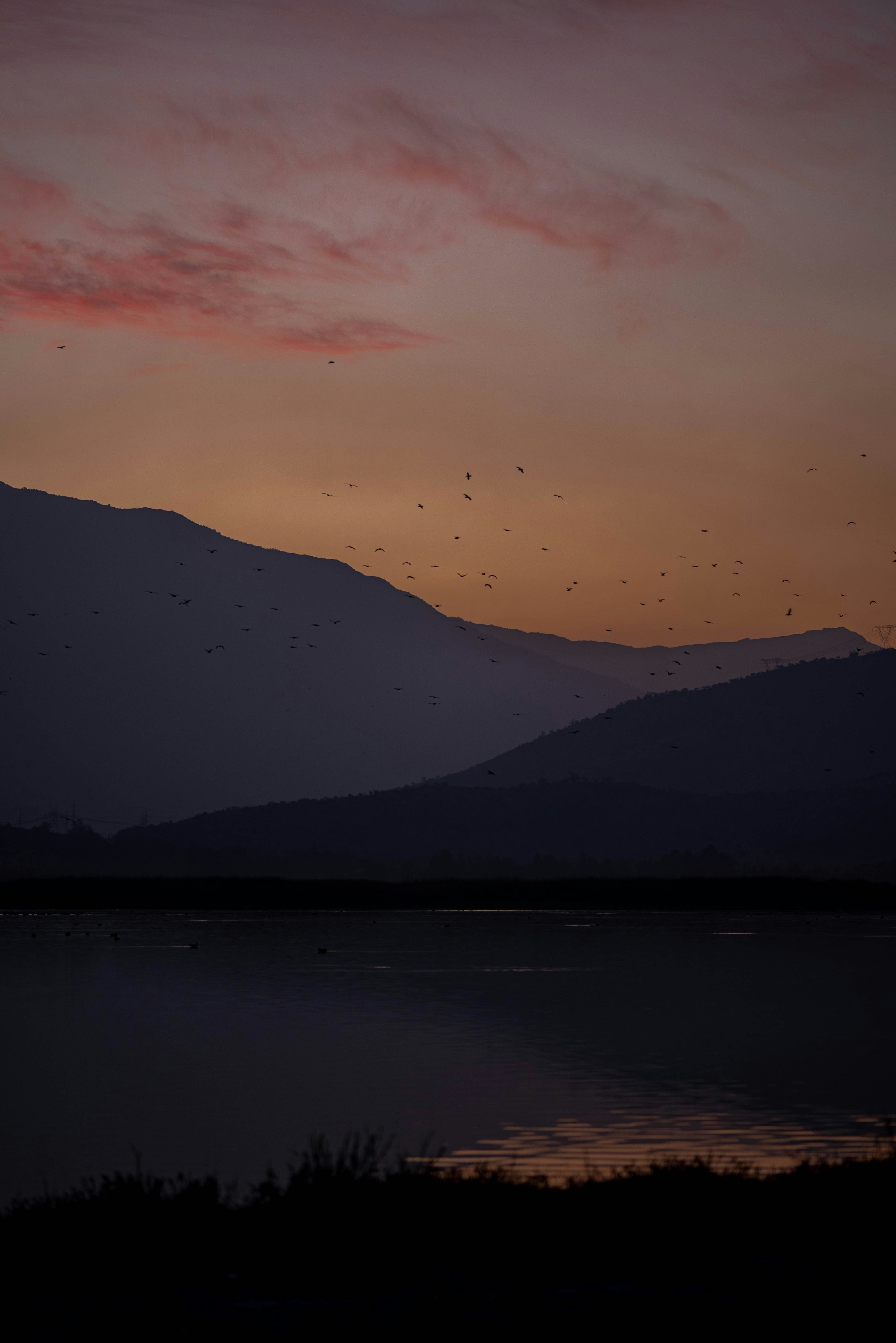 silhouette of mountains near body of water during night time