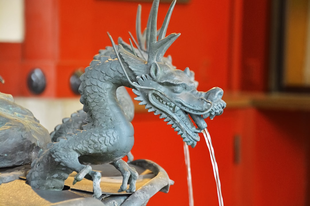 grey dragon figurine on brown wooden table