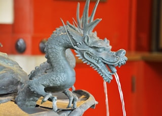 grey dragon figurine on brown wooden table