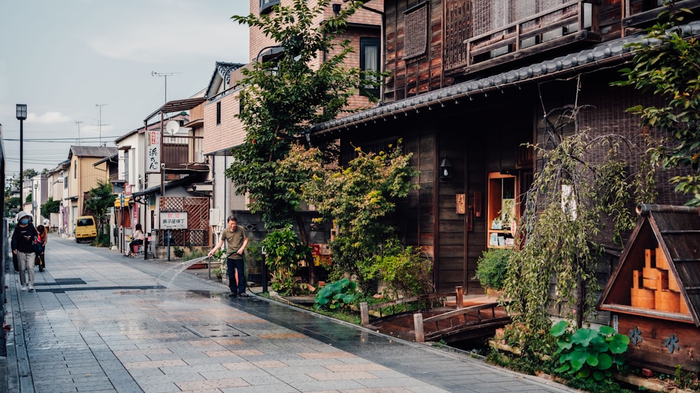 昼間は緑の木々のそばの茶色い木造住宅