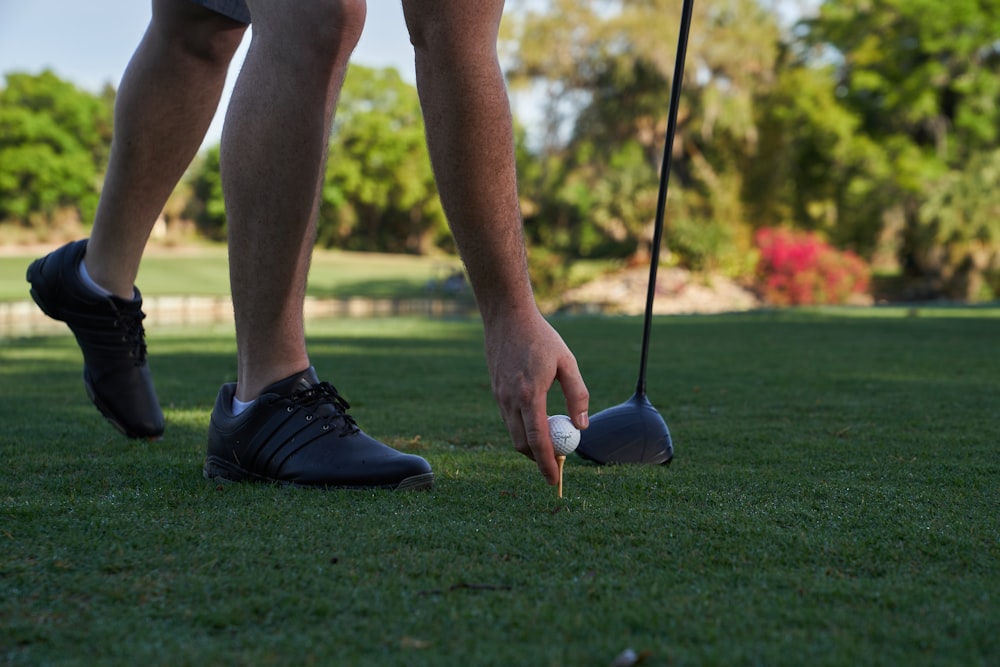 person holding golf club during daytime