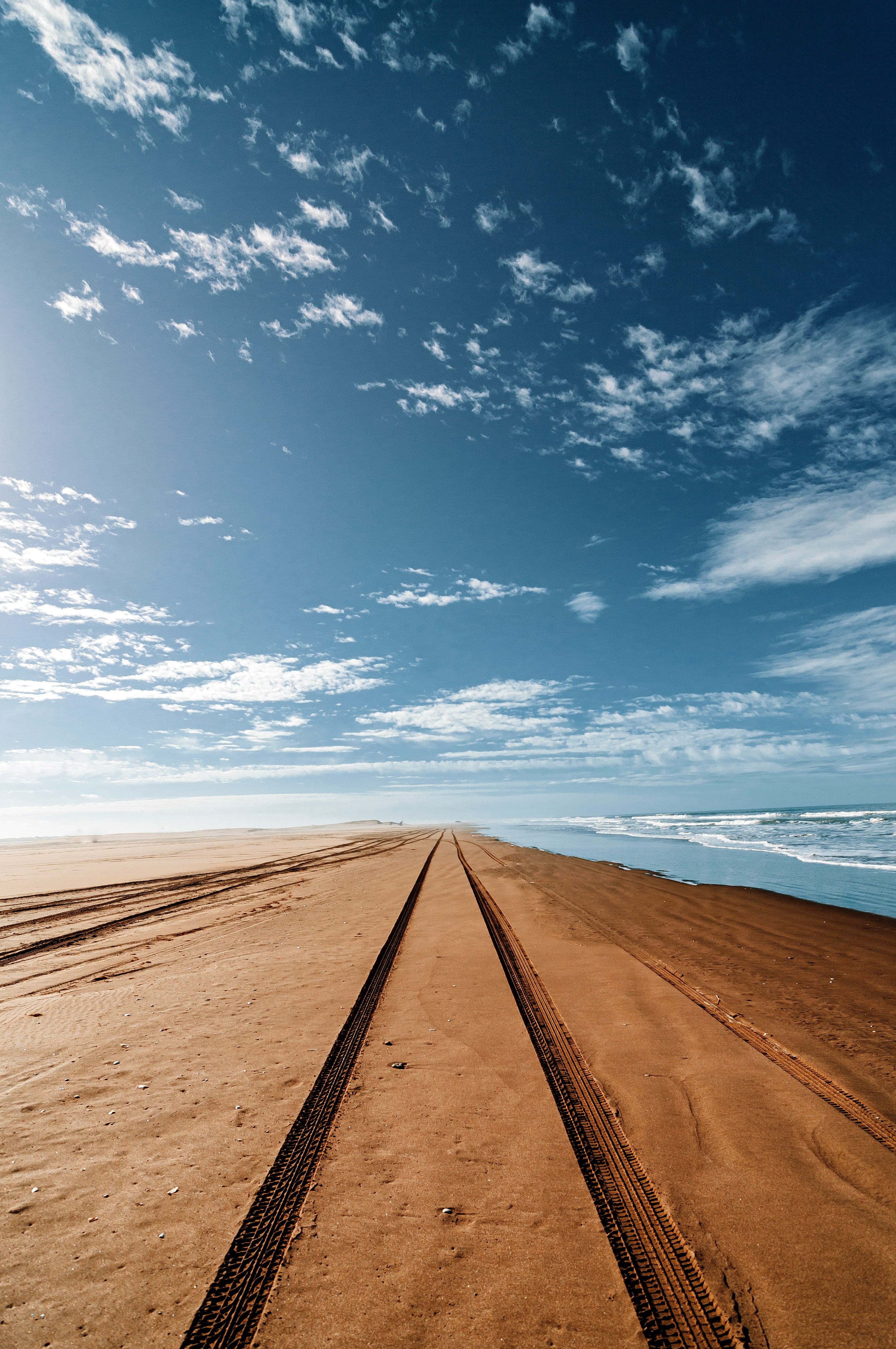 brown sand near sea under blue sky during daytime