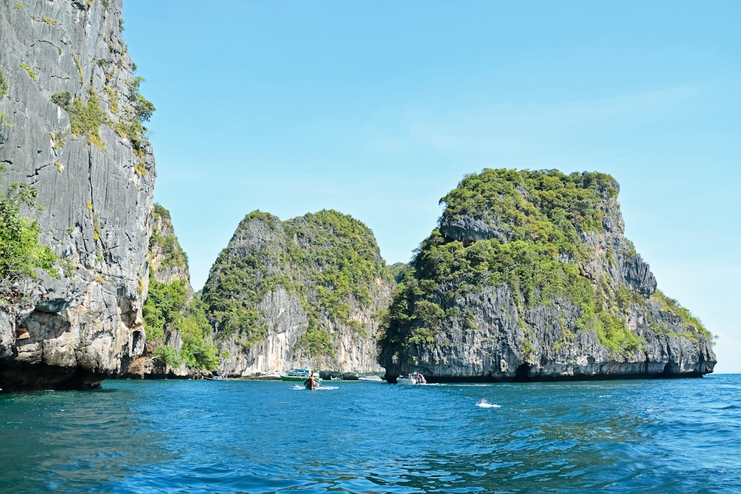green and brown rock formation on blue sea under blue sky during daytime