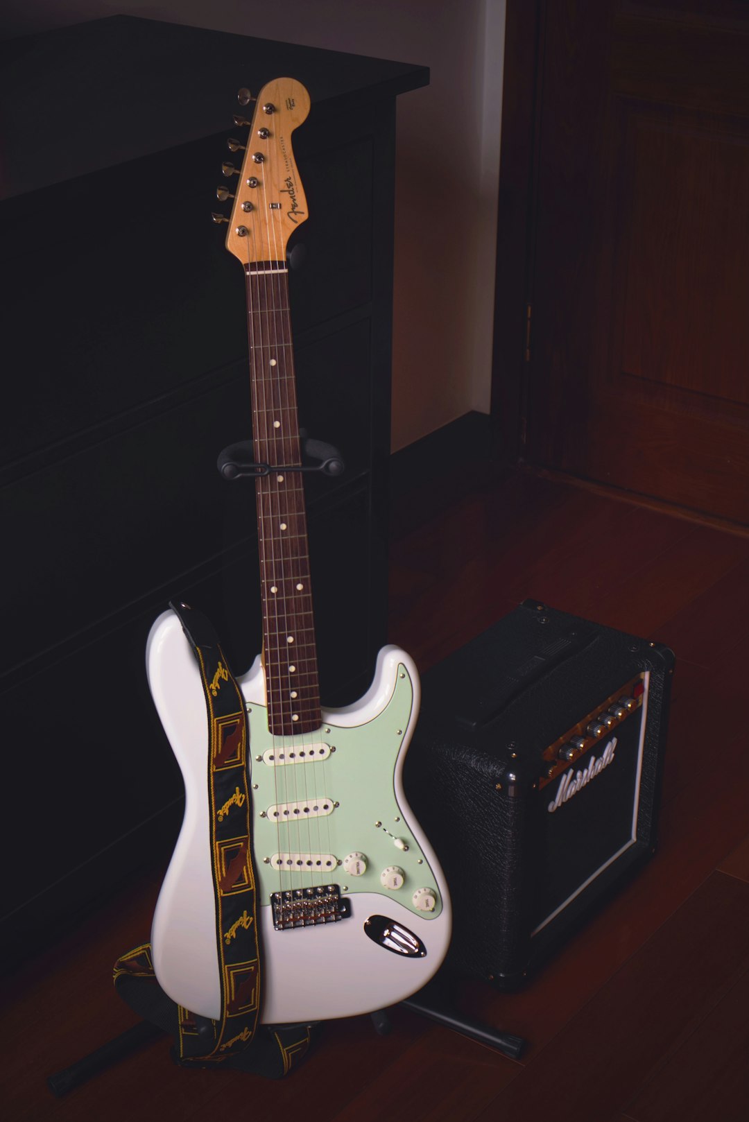 white and brown stratocaster electric guitar