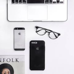 A stylish flat lay of elegant sales materials including brochures and digital devices