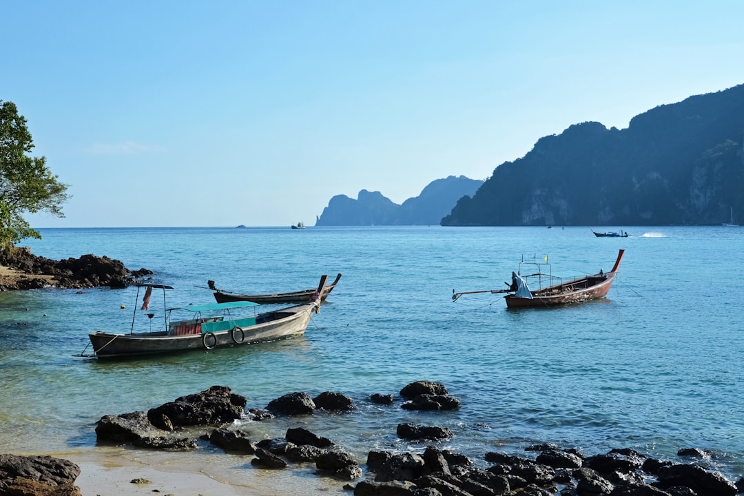 white and blue boat on sea shore during daytime