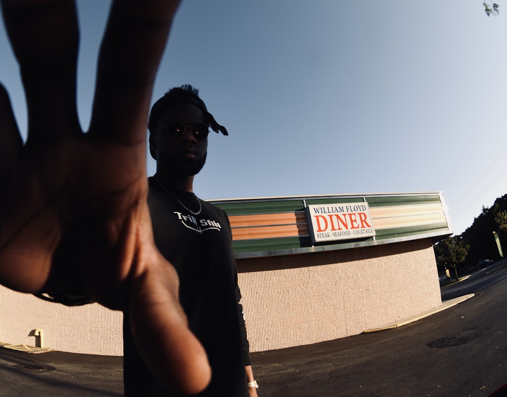 topless man wearing black sunglasses raising his right hand