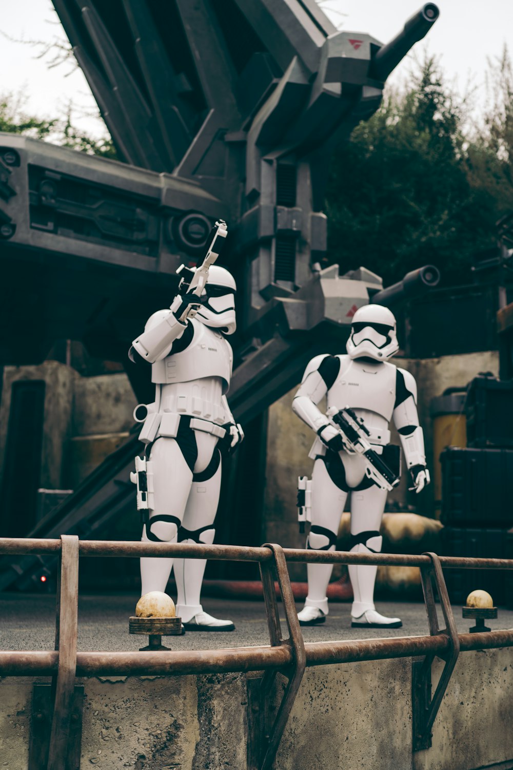 2 white and black robot standing on brown wooden fence during daytime