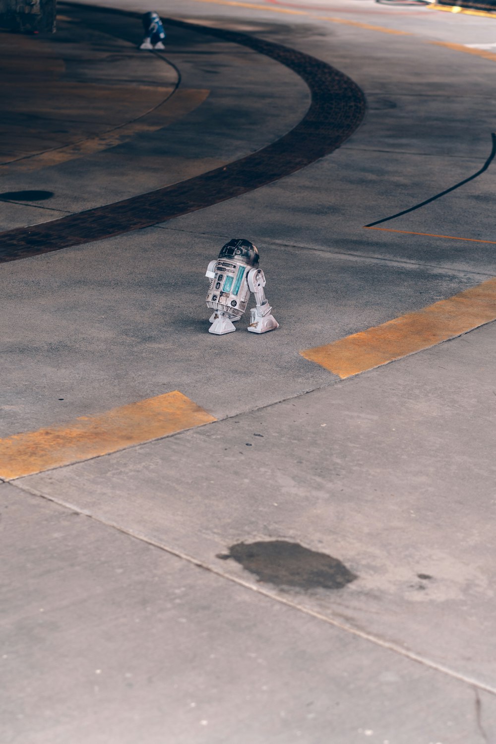 man in white and black jacket and pants sitting on gray concrete floor