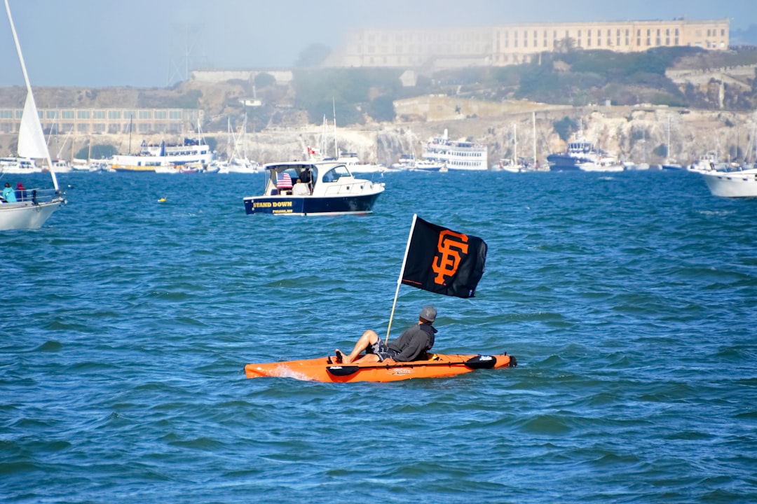 man in blue shirt riding on yellow kayak on body of water during daytime