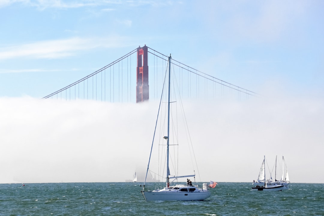 white sailboat on sea under white sky during daytime