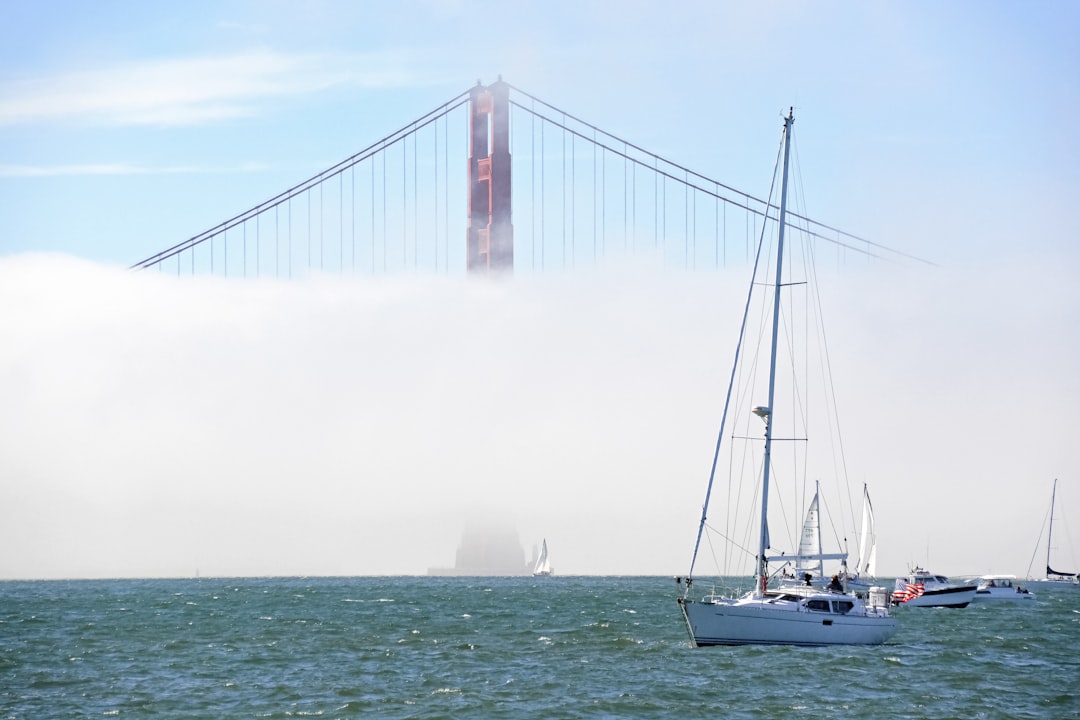 white sailboat on sea under white sky during daytime