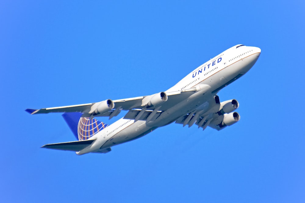 white and blue passenger plane in the sky