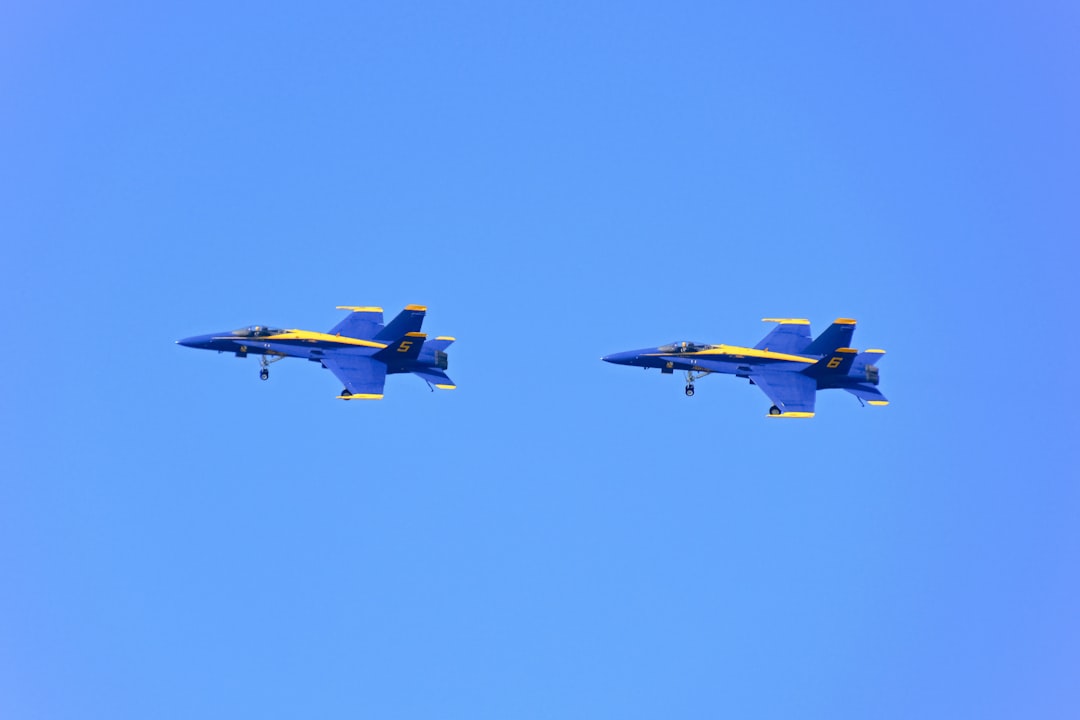 blue and yellow jet plane in mid air during daytime