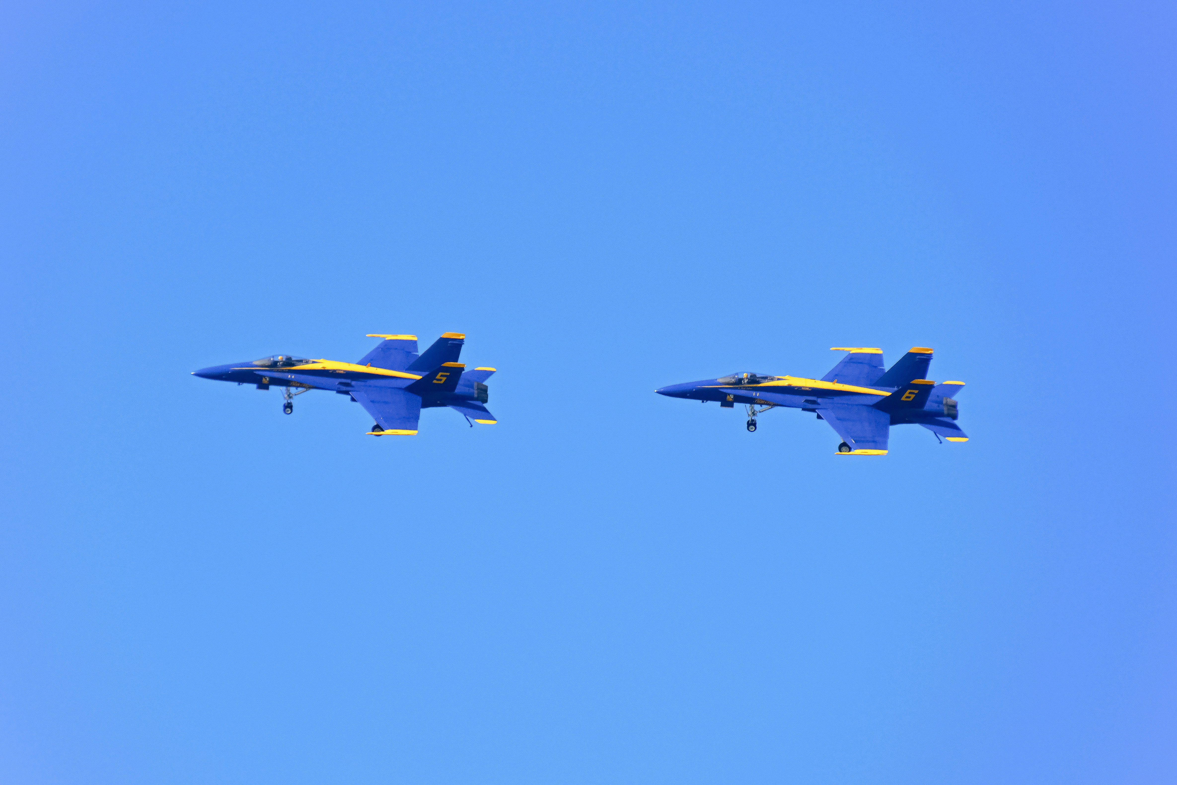 blue and yellow jet plane in mid air during daytime