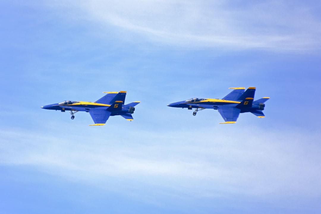 blue and yellow jet plane in mid air during daytime