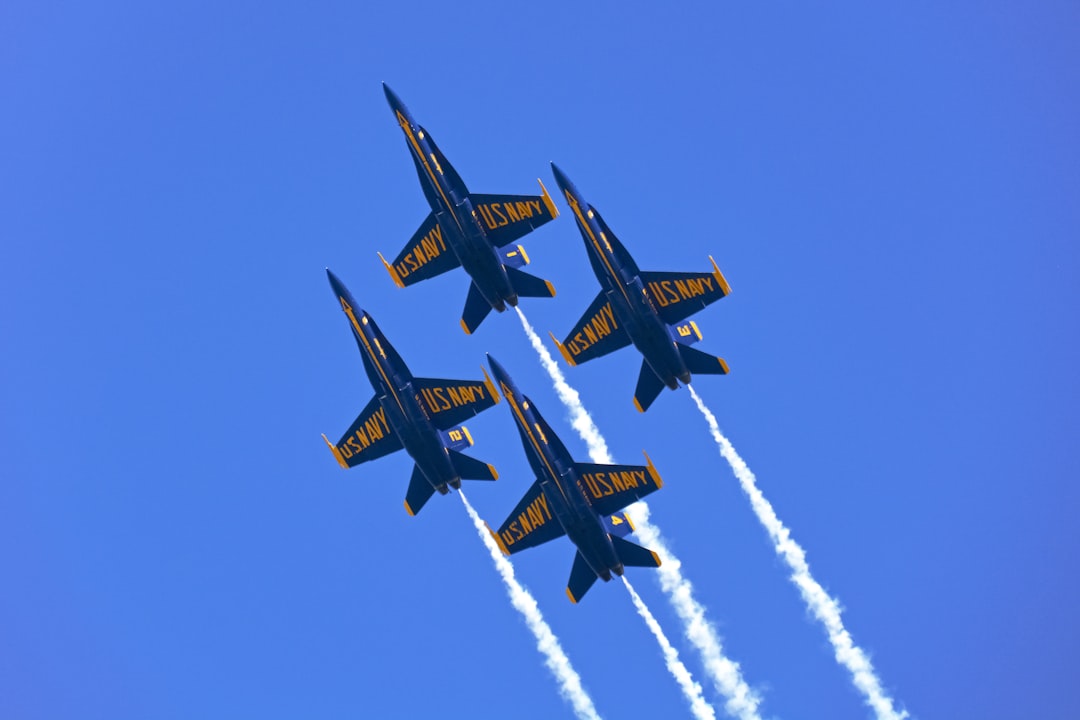 four black and yellow jet planes in mid air during daytime