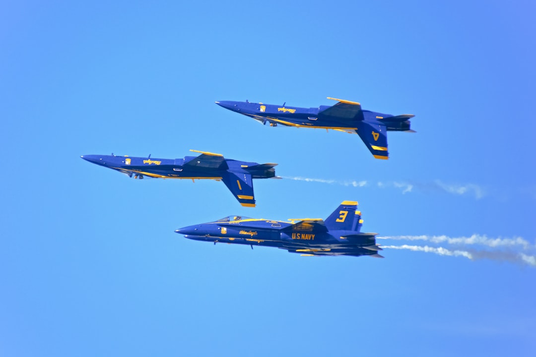 blue and yellow fighter plane in mid air during daytime