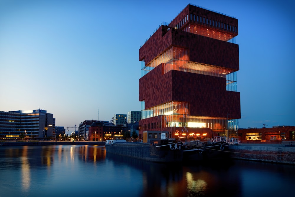 brown concrete building near body of water during night time