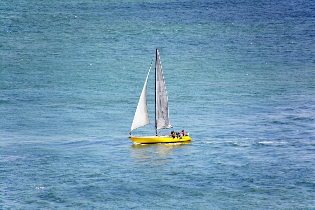 yellow and white sailboat on blue sea during daytime