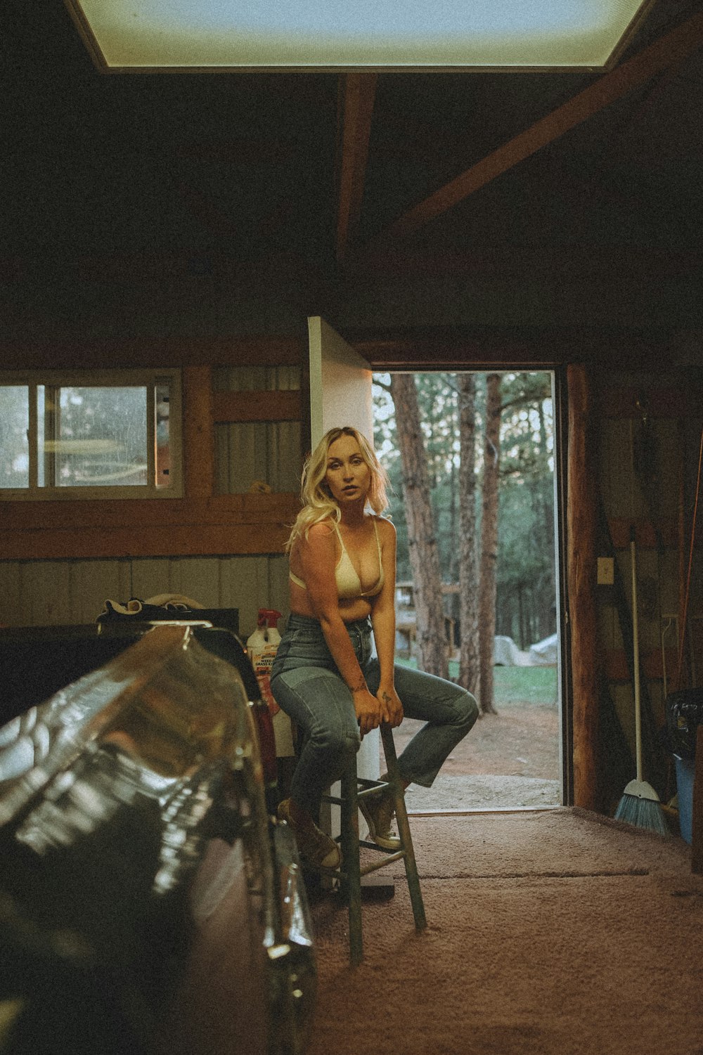 woman in black tank top and blue denim jeans sitting on chair