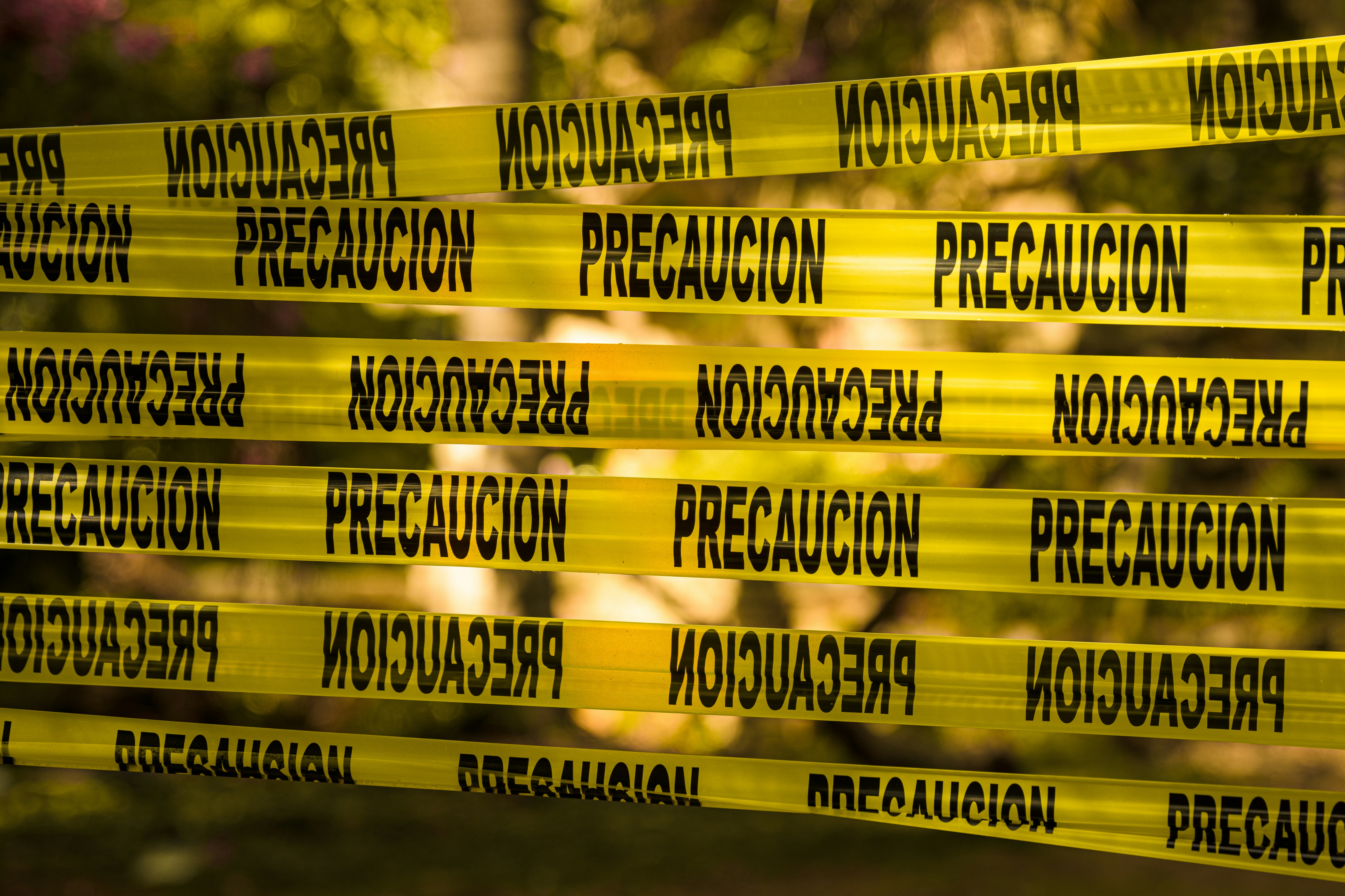 Yellow caution tape with spanish text "precaucion"