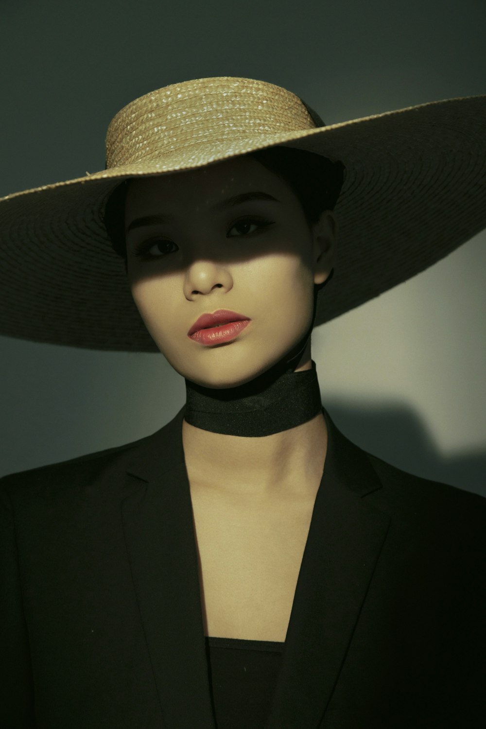 woman in black suit wearing brown sun hat