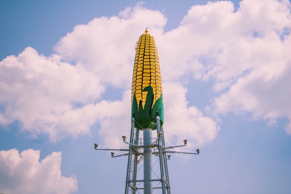 green and yellow tower under white clouds and blue sky during daytime