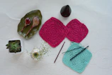 Flat lay of crochet materials next to finished small crochet baskets on a rustic surface.