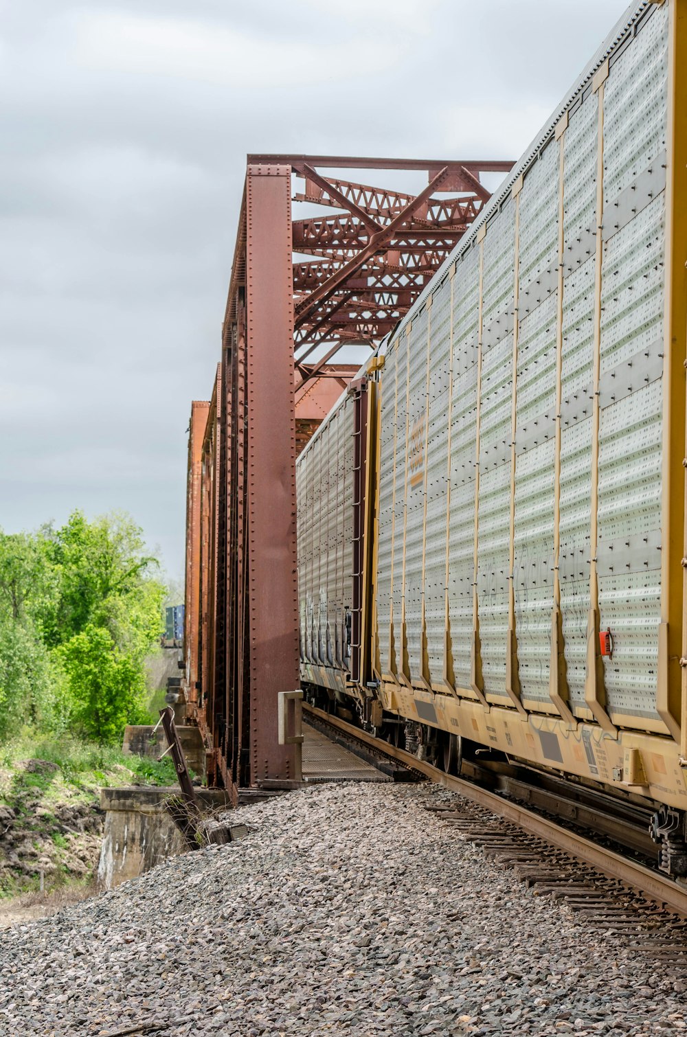 brown metal train rail near green trees during daytime