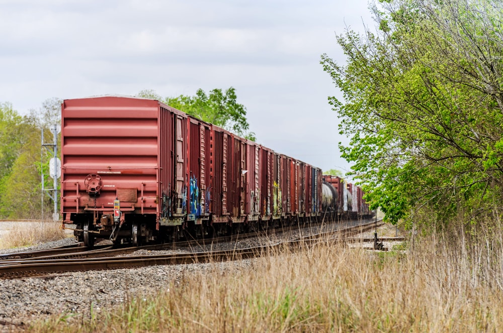 red train on rail tracks during daytime