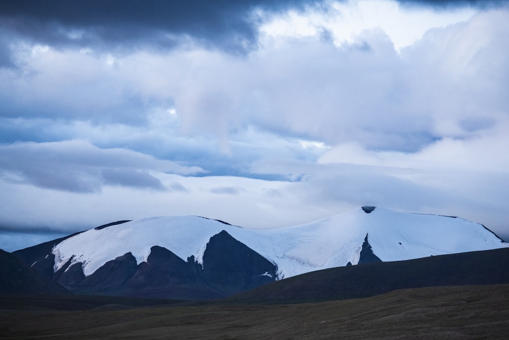 snow covered mountain under cloudy sky during daytime