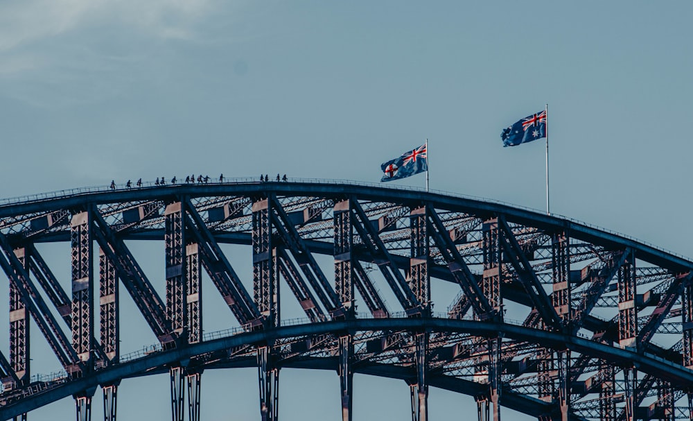 drapeau rouge et blanc sur un pont en acier noir sous un ciel bleu pendant la journée