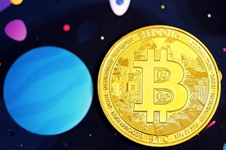 A golden Bitcoin coin adorned with intricate circuit designs is prominently placed against a background that is reminiscent of outer space, featuring large planet-like shapes in shades of blue and purple and small scattered dots in various colors.