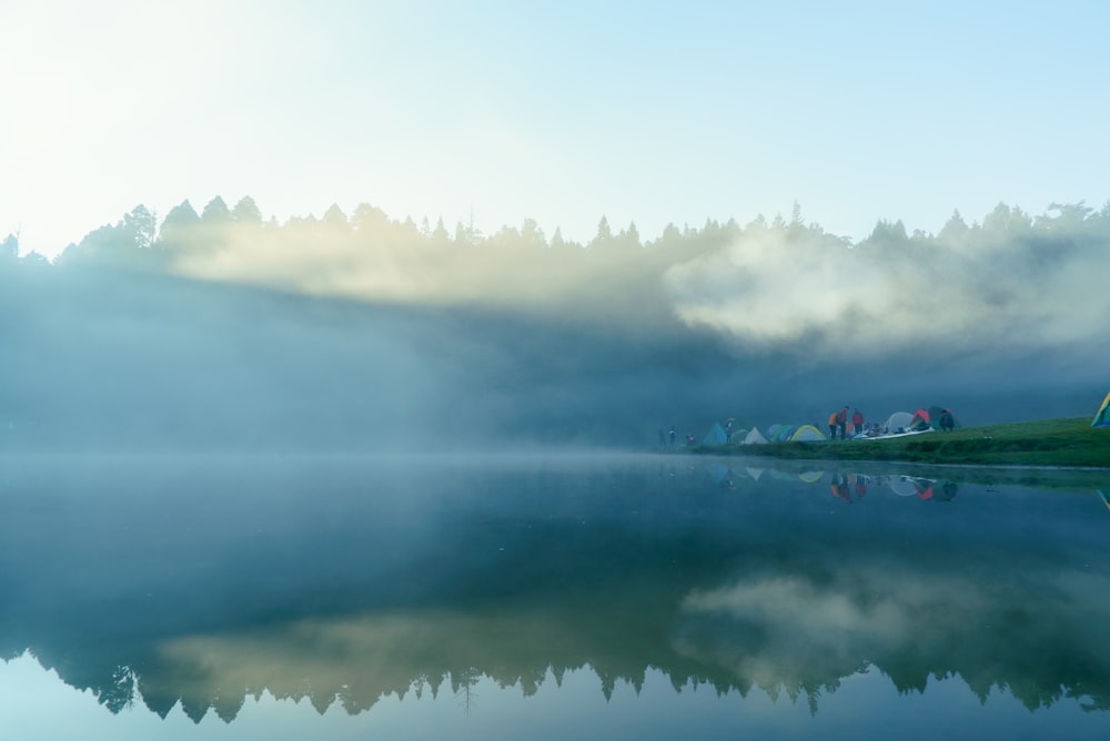 body of water under white clouds during daytime