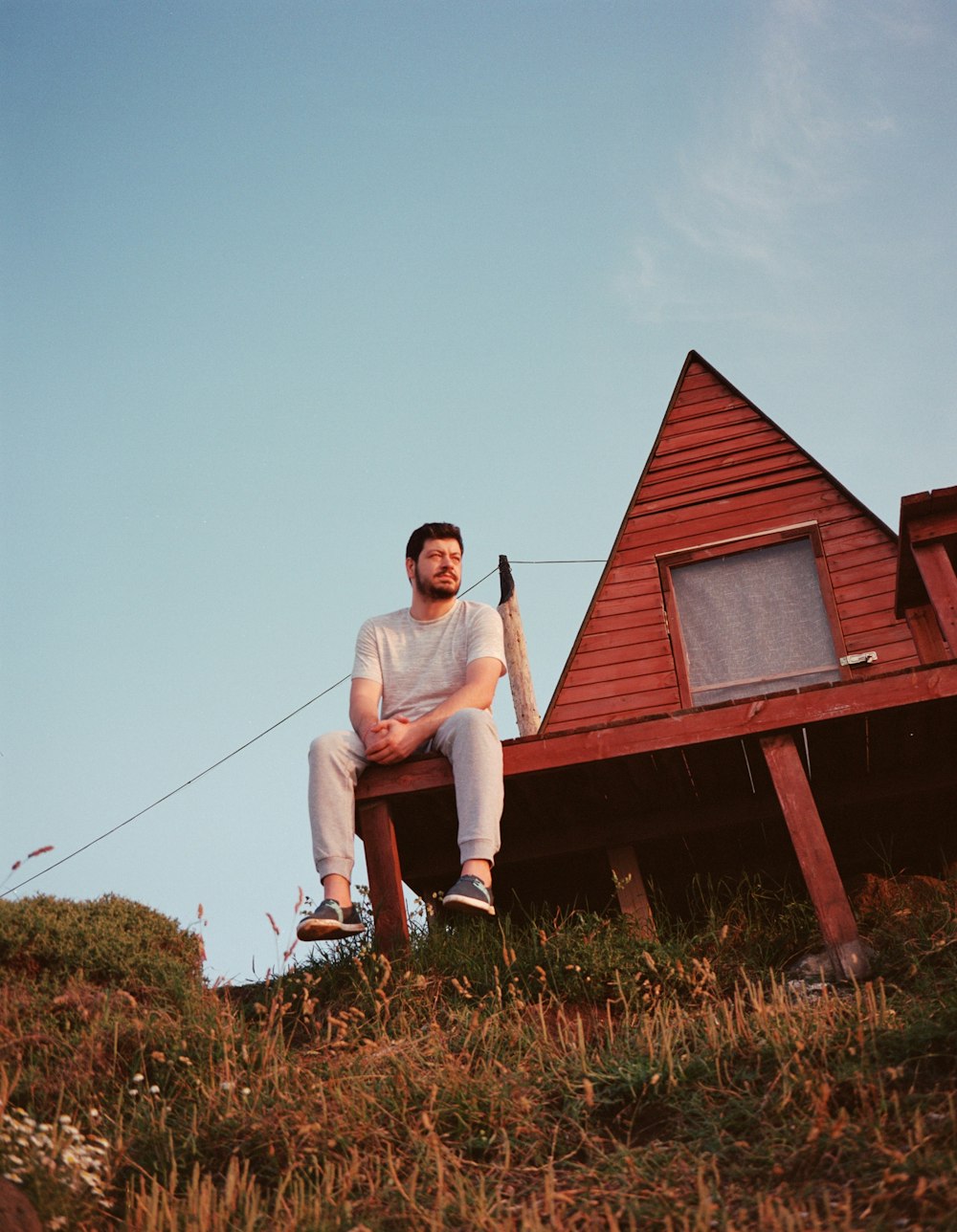 a man sitting on top of a wooden building