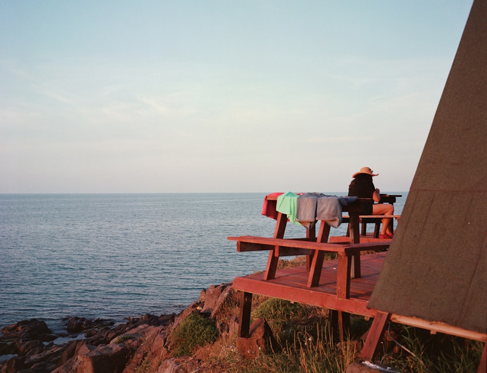 a person sitting on a bench overlooking the ocean